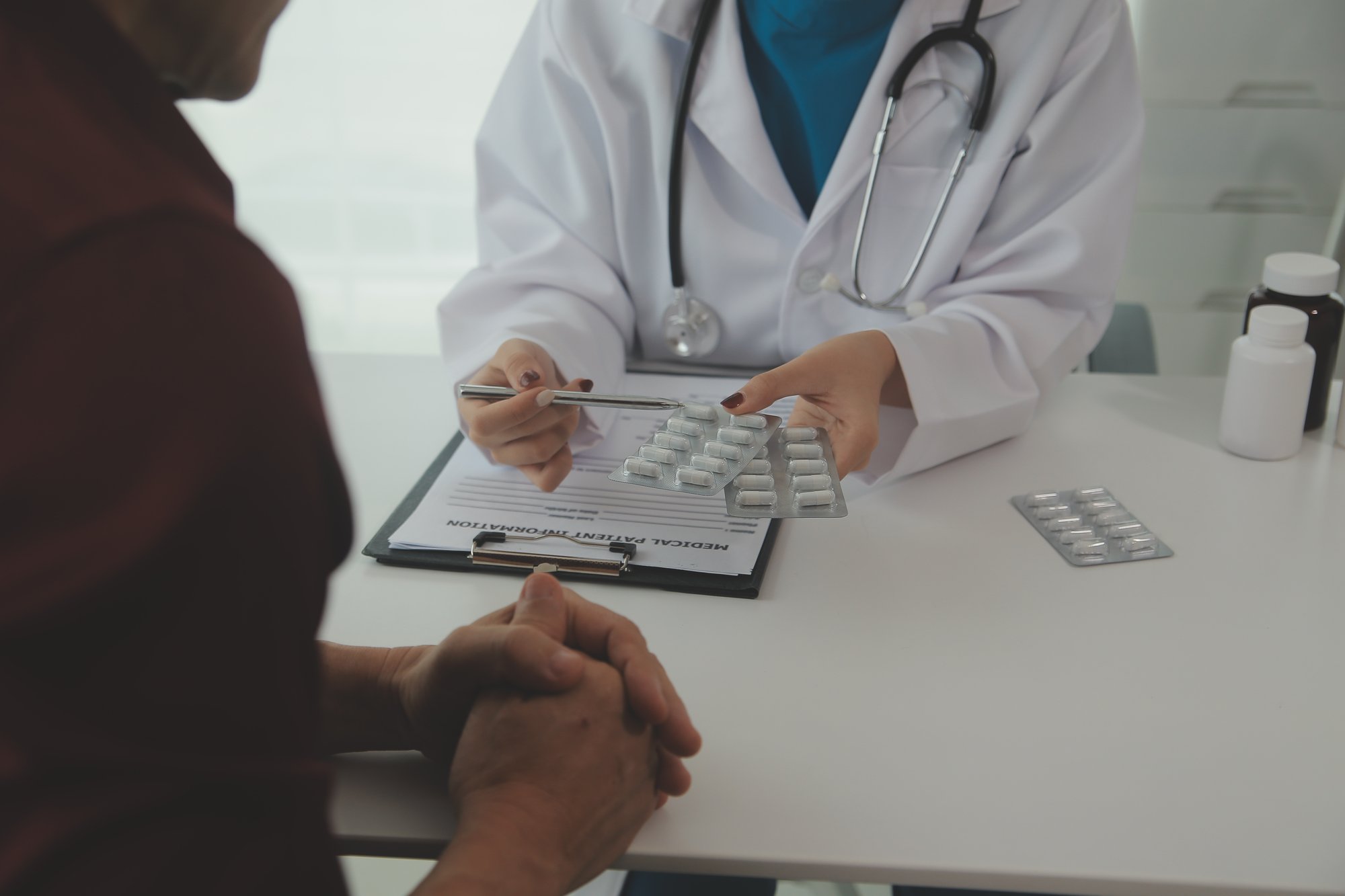 vecteezy_doctor-prescribing-medicine-giving-pills-to-senior_48769252